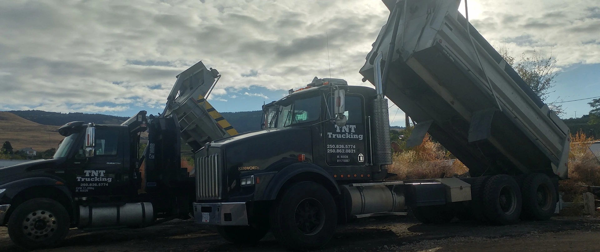 TNT Kelowna dump trucks providing hauling and trucking services at a construction site
