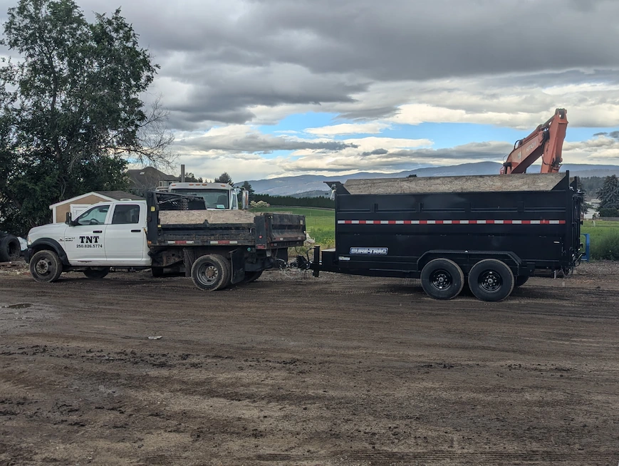 TNT Kelowna dump truck and dump trailer with excavator on a general contracting job site in Kelowna, BC