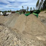 Aggregate stockpiles beside a mobile screening plant for materials supply and spoils management in Kelowna, BC