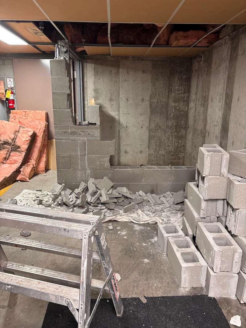 Interior selective demolition removing a cinder block wall in a basement, Kelowna, BC