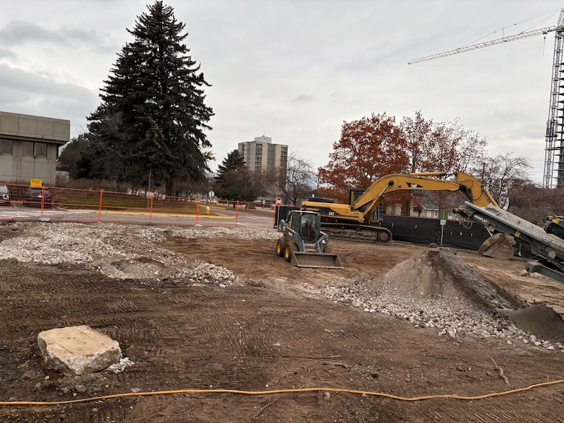 Skid steer grading and excavator sorting aggregate during site clearing and preparation in Kelowna, BC