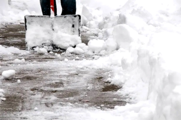 TNT Kelowna truck removing snow from a residential driveway in Kelowna, BC.