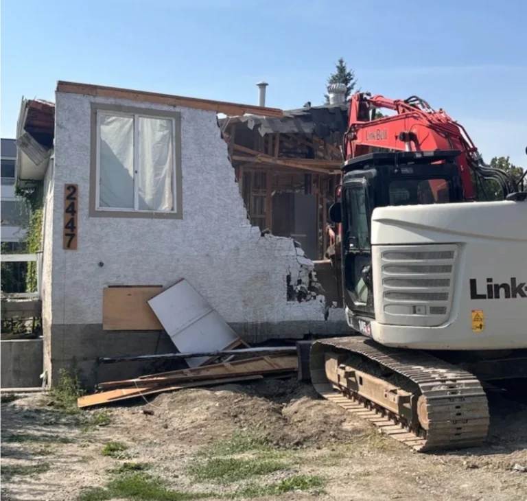 Excavator demolishing a residential house during teardown and site cleanup in kelowna